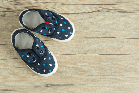 blue kid shoes  put on wood background in top view.の写真素材