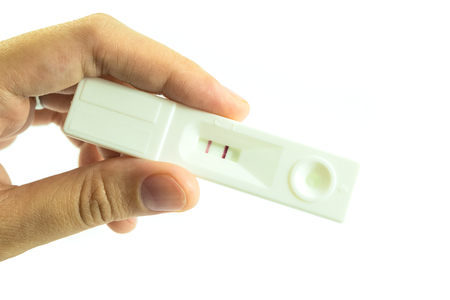 Woman hand hold pregnancy test that result is two scale meaning having babyの写真素材