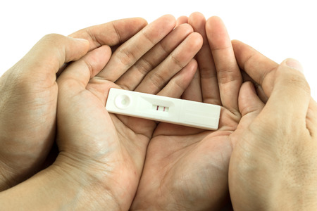 man hands hold woman hands and pregnancy tests put on that.Test result is two lines that means they are having childrenの写真素材
