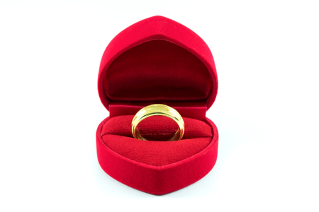 Gold wedding ring in red heart gift box isolate on white backgroundの写真素材