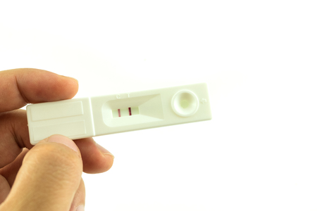 Woman hand hold pregnancy test that result is two scale meaning having babyの写真素材
