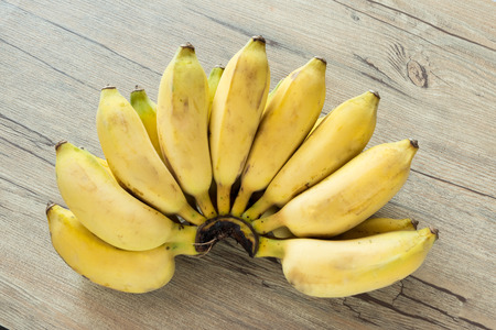 Raw cultivated banana on wood background and empty space.の写真素材