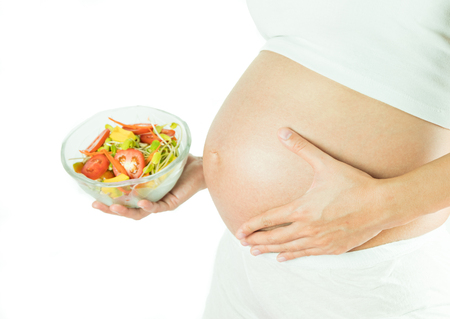 pregnant women with white underwear hold mix salad,concept vegestable is good for baby.の写真素材