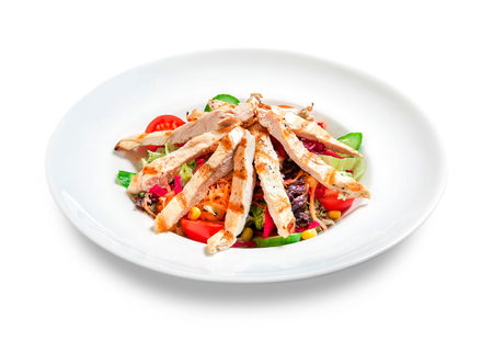 mixed salad with meat and vegetables in plate on white backgroundの写真素材