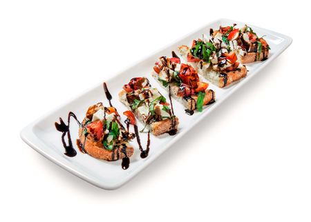 lot of mini sandwiches (toasts) on a platter on white background