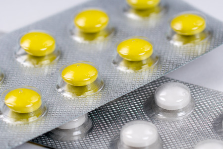 close up of yellow and white pills in blisters