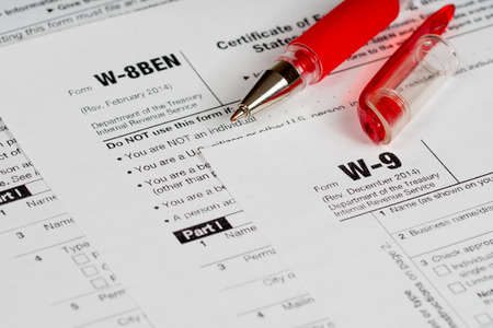 tax reporting forms with opened red penの写真素材