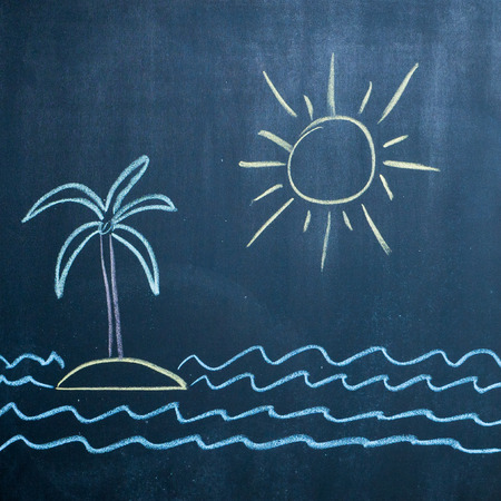 sun, sea and island with palm drawing on black chalkboardの写真素材