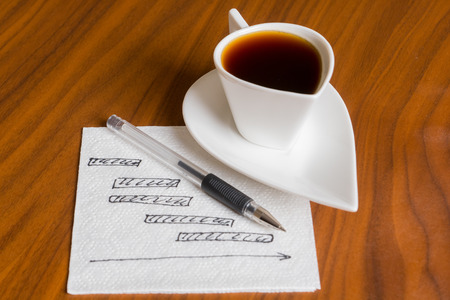 coffee cup with handwriting project chart on square napkinの写真素材