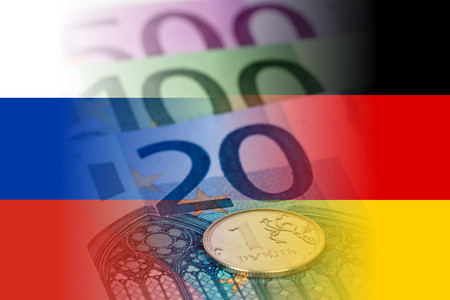 russia and germany flags with euro banknotes and ruble coin mixed imageの写真素材