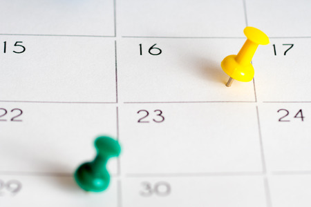 green yellow pins on calendar gridの写真素材