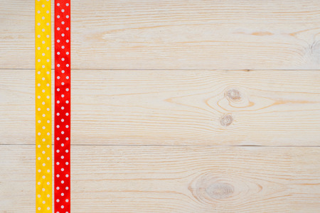 yellow and red polka dot ribbons on retro wooden tableの写真素材