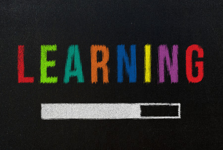learning with progress bar on black chalkboardの写真素材