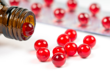 vitamin e capsules with opened bottle and blister pack on whiteの写真素材