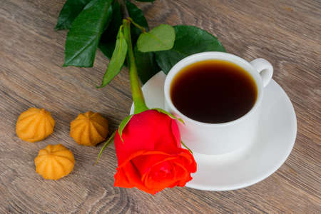 red rose with coffee cup on wooden tableの写真素材