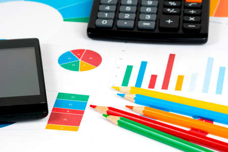 colorful charts and pencils with calculator and mobile phoneの写真素材