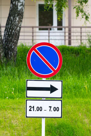 no parking road sign with direction arrow and time limitの写真素材