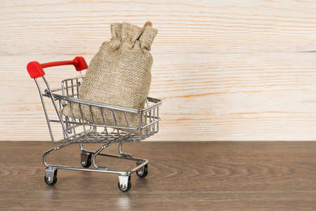 shopping cart with gift bag over wooden background, christmas conceptの写真素材