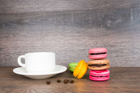 coffee cup and colorful macaroons on wooden tableの写真素材