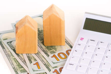 wooden house model with dollars banknotes, buy or rent conceptの写真素材