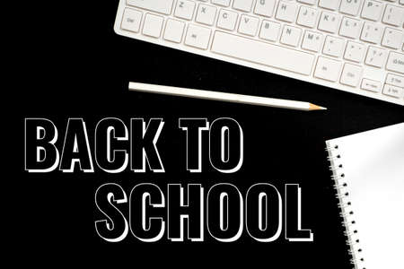 back to school, text over black board, keyboard and pencilの写真素材