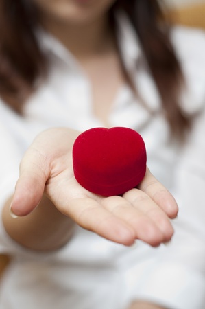 an image of red engagement box holding by hand of young girlの写真素材