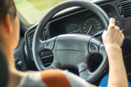 Hands of a female driver on steering wheelの写真素材