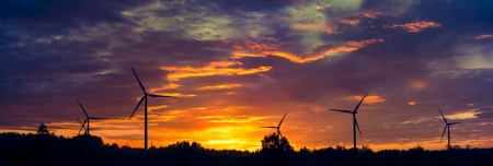 A silhouette of windturbines on a amazing sunsetの写真素材