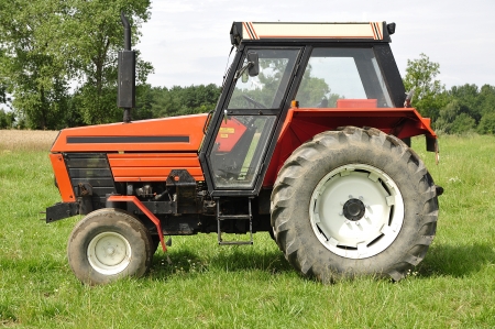 Red tractor on the meadowの写真素材