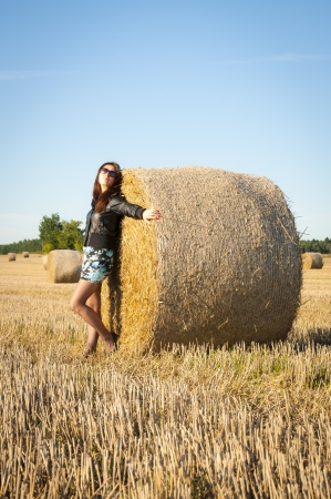 An image of brunette girl portrait and straw bale の写真素材