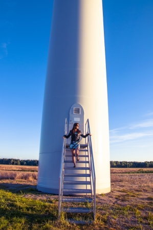 Girl standing on entrance to windturbineの写真素材