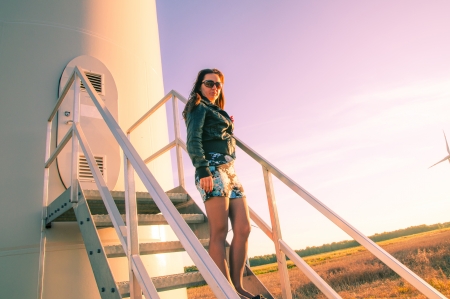 Woman standing on entrance to wind turbineの写真素材