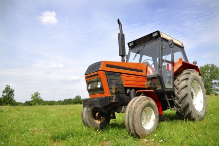Red tractor on the meadowの写真素材