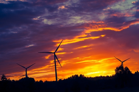 A silhouette of windturbines on a amazing sunsetの写真素材