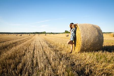 An image of brunette girl portrait and straw bale の写真素材