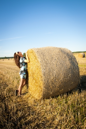 An image of brunette girl portrait and straw bale の写真素材