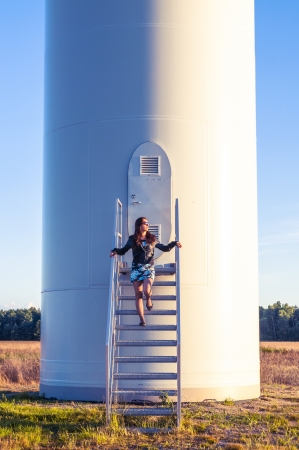 Girl standing on entrance to windturbineの写真素材