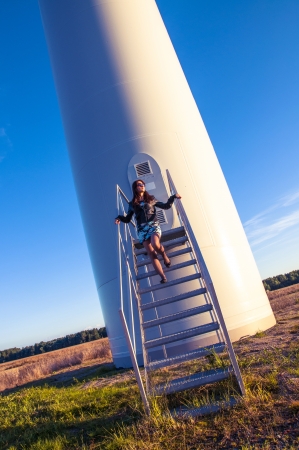 Girl standing on entrance to windturbineの写真素材