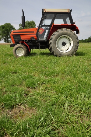 Red tractor on the meadowの写真素材