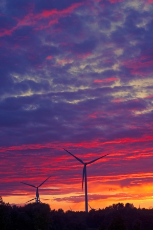 A silhouette of windturbines on a amazing sunsetの写真素材
