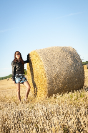 An image of brunette girl portrait and straw bale の写真素材
