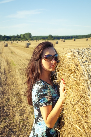 An image of brunette girl portrait and straw bale の写真素材