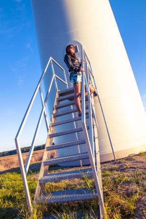 Girl standing on entrance to windturbineの写真素材