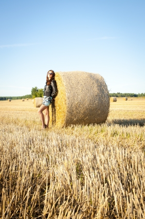 An image of brunette girl portrait and straw bale の写真素材