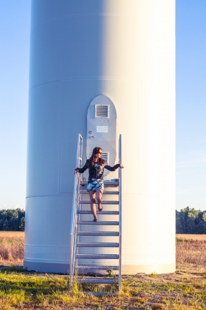 Girl standing on entrance to windturbineの写真素材
