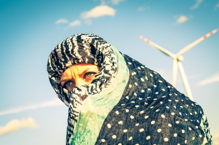An image of muslim girl and windturbine in the backgroundの写真素材