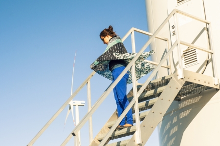An image of girl holding canvas-cape and windturbine in backgroundの写真素材