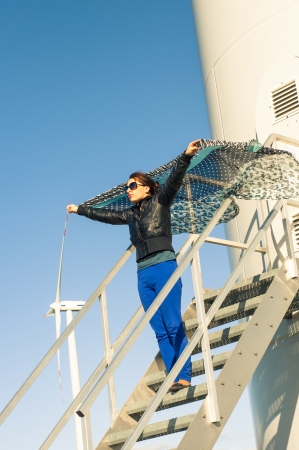 An image of girl holding canvas-cape and windturbine in backgroundの写真素材