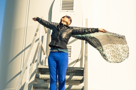 An image of girl holding canvas-cape and windturbine in backgroundの写真素材