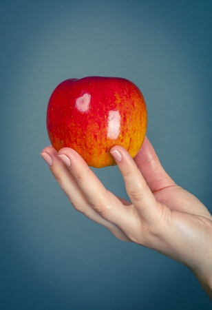 an image of red apple on female handの写真素材